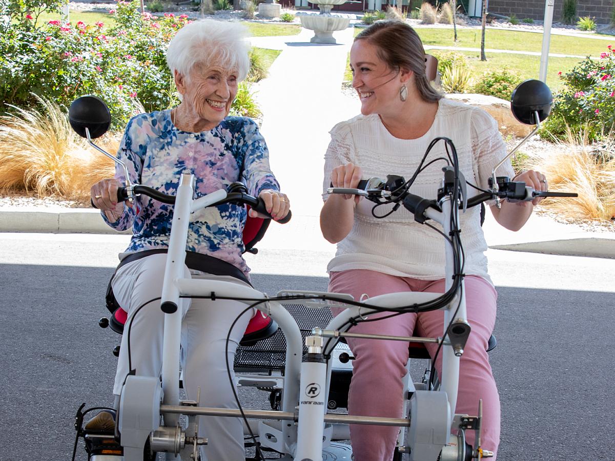 Two women riding on an adaptive bicycle