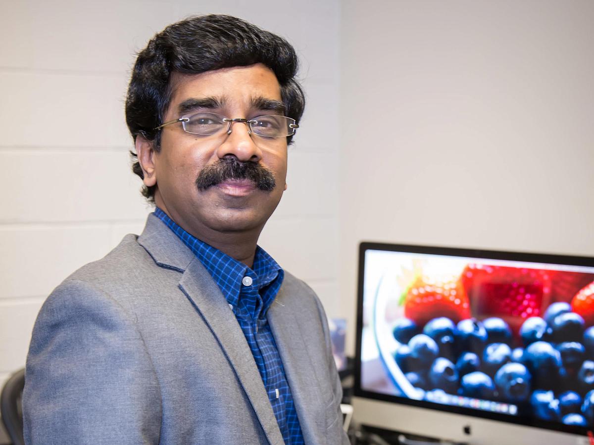 Professor Velayutham sitting at his desk