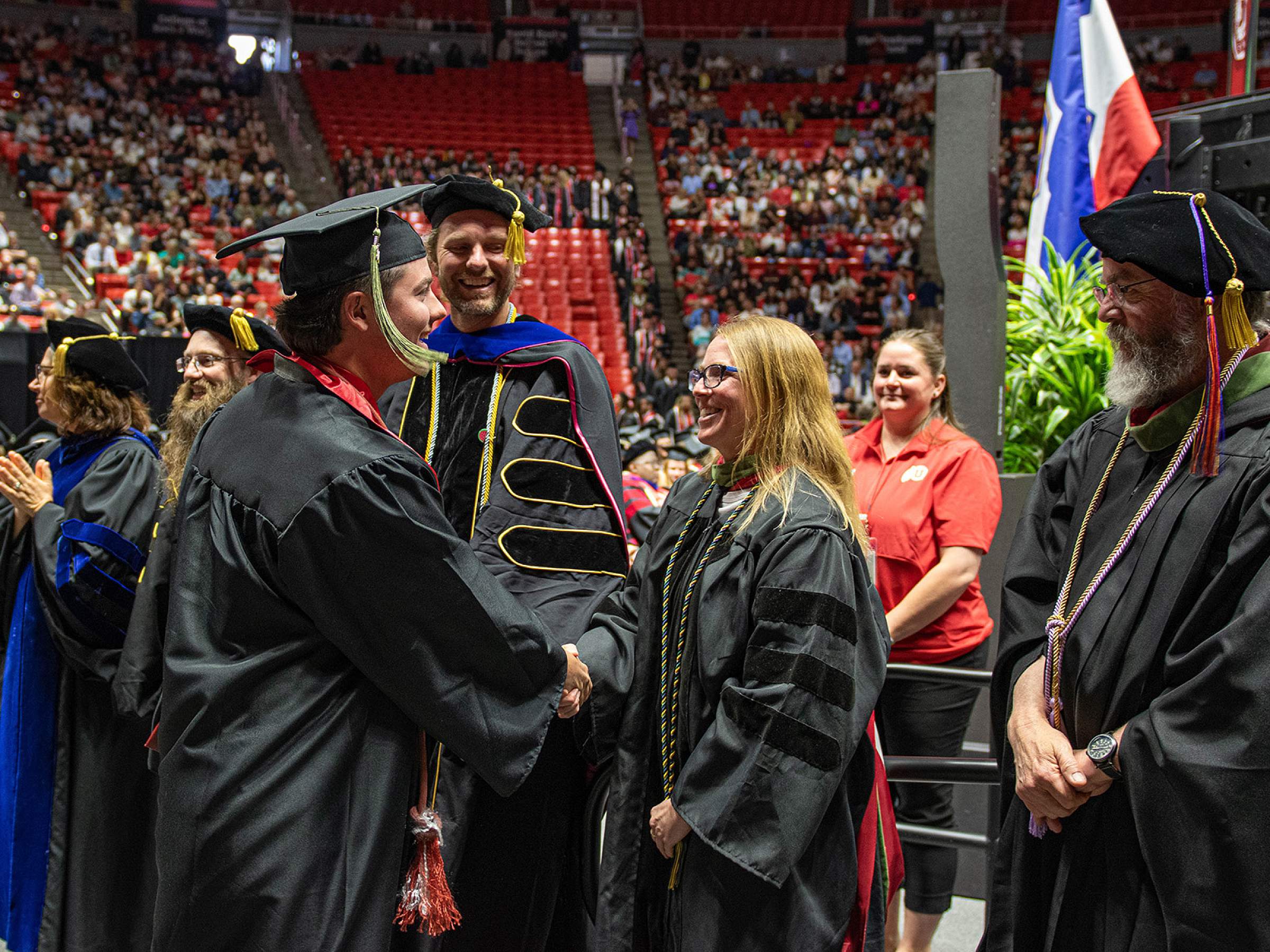 Student and faculty shaking hands at graduation