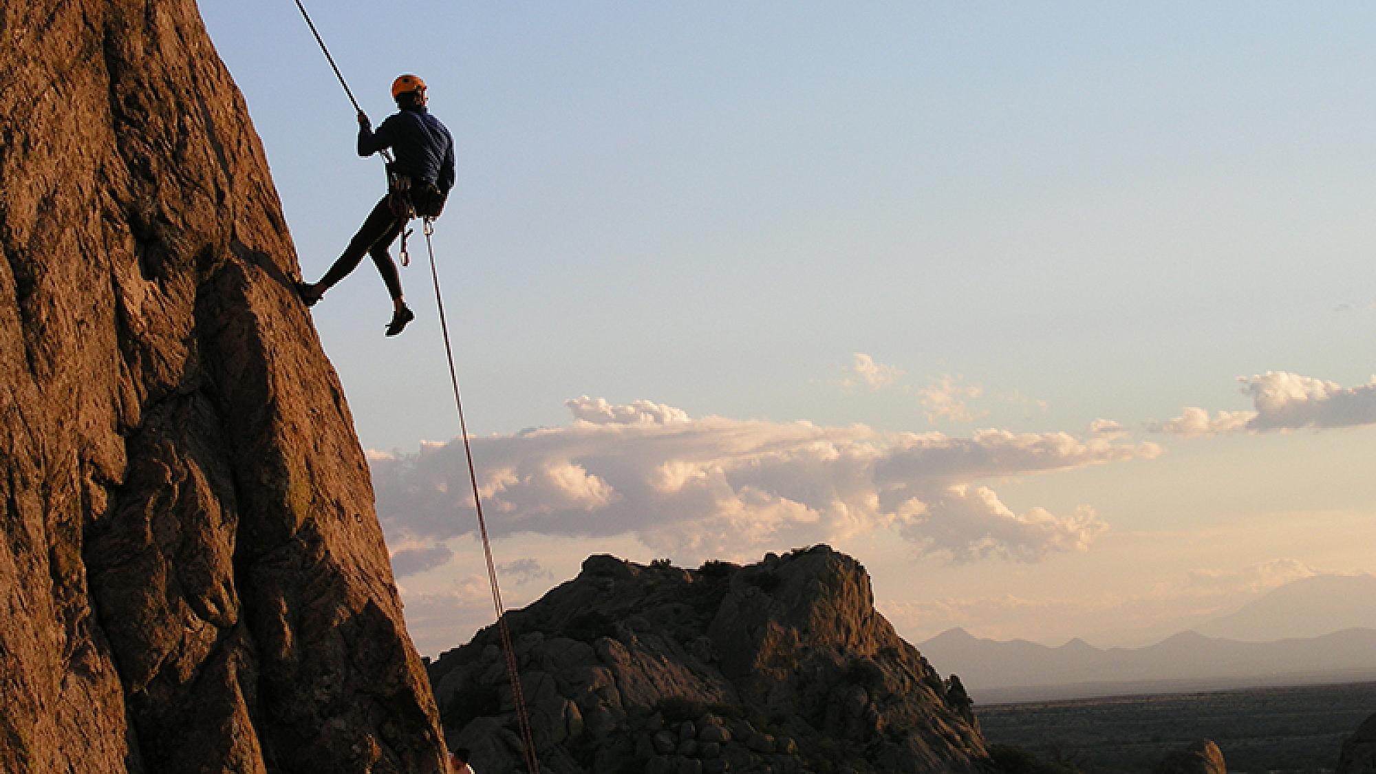 Person repelling down a mountain